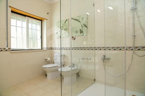 a bathroom with a toilet and a glass shower at Villa BelaVista by ACasaDasCasas in Ericeira