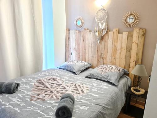 ein Schlafzimmer mit einem Bett mit einem hölzernen Kopfteil in der Unterkunft Appartement Spa et Sauna privatif - Terrasse in Carcassone