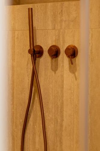 a shower with two brown knobs on a wall at Élégant duplex 8 pers clim et suite parentale in Vallauris