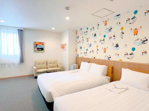 a hotel room with two beds and a chair at ステラサイト函館 in Hakodate