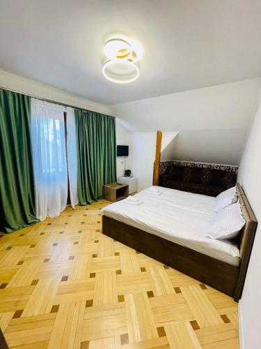 トビリシにあるHotel at homeのベッドルーム(大型ベッド1台、緑のカーテン付)