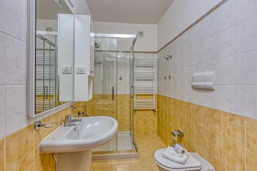 a bathroom with a sink and a shower at Budget Village Apartments - Porto Letizia in Porlezza