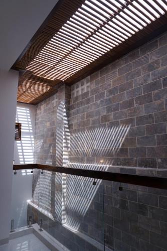 a building with a brick wall with a wooden roof at CLOVER Homestay Phú Yên in Phường Sáu