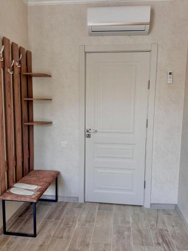 a room with a white door and a bench at Bee Planet Garni in Garni