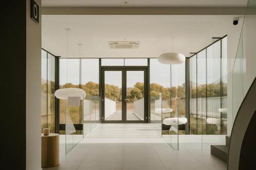a room with glass walls and a hallway with chairs at OFF in Wavre