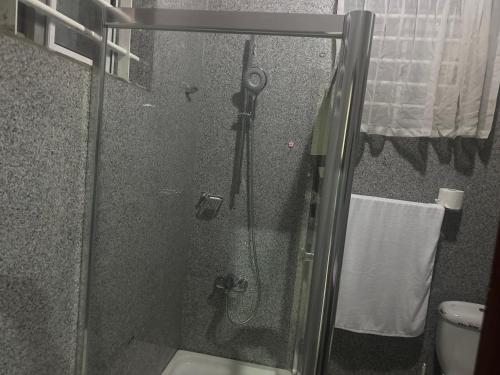 a shower with a glass door in a bathroom at Biztourism Gh in Accra