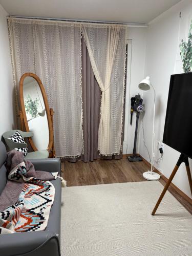 a living room with a couch and a mirror at Luna stay in Seoul