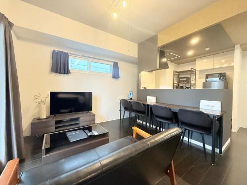 a living room with a couch and chairs and a television at Sun Court Nango-dori サンコート南郷通 501 in Sapporo