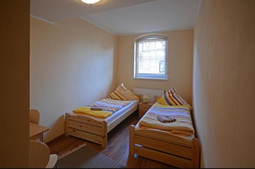 two beds in a small room with a window at Pension Am Pilgerbach in Baunatal
