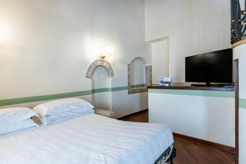 a bedroom with a bed and a flat screen tv at Hotel Locanda Remedio in Venice