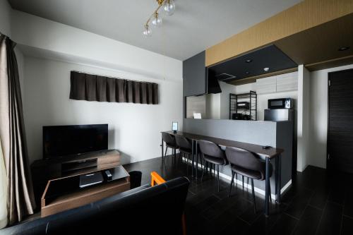 a living room with a table and chairs and a television at Sun Court Nango-dori サンコート南郷通 501 in Sapporo