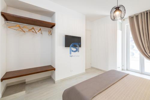 a bedroom with a bed and a tv on a wall at Villa Irene Deluxe in Campofelice di Roccella