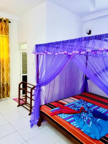 a bed with a canopy in a room at Disna Place in Unawatuna