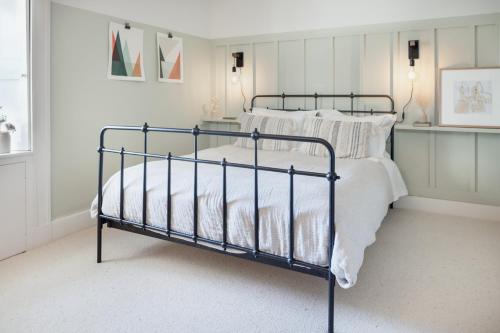 a bedroom with a metal bed with white sheets at The Dell of Abernethy - A Woodland hideaway in Nethy Bridge