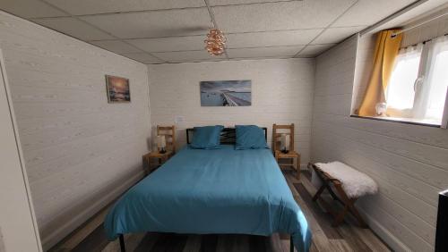una camera da letto con un letto blu in una stanza di Appartement 200m carré mont dore a Le Mont-Dore