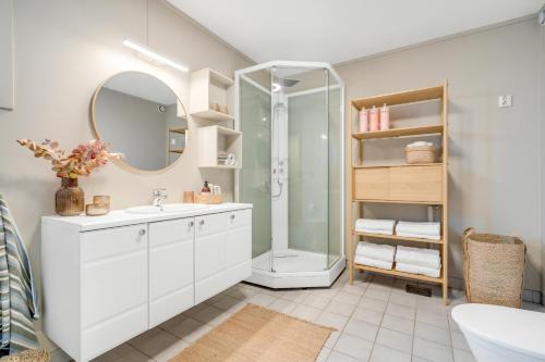 a white bathroom with a shower and a sink at Spacious Arctic Apartment Near Tromsøs Top Sights in Tromsø