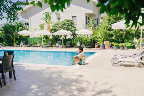 a child sitting by the pool at a hotel at WEST HOUSE EXCLUSIVE HOTEL in Göcek