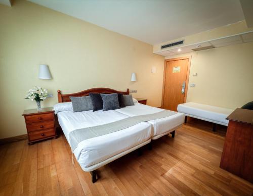 a large bedroom with two beds and a table at Hotel Villa De Ermua in Ermua