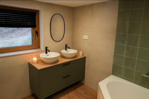 two sinks in a bathroom with a mirror and a tub at Le Chavot - Chalet 140 m² pour 8 personnes in Cohennoz