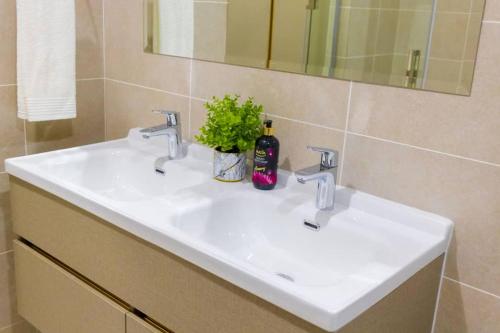 a bathroom with a white sink and a mirror at Emarald sky views in Johannesburg