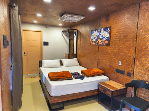 a bedroom with a bed in a wooden wall at Gambhiraa Resorts in Kolli Hills