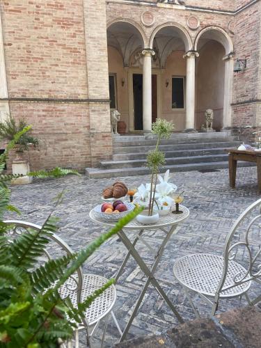 a table with a plate of food on it in a courtyard at Villa Santa Maria al Poggio in Porto San Giorgio