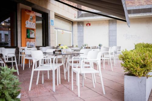 a group of white chairs and tables on a patio at Hotel Villa De Ermua in Ermua
