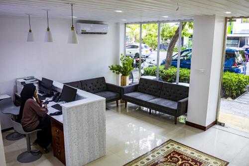 a person sitting at a desk with a computer at Terminal 27 Hotel in Hulhumale