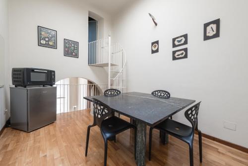 a dining room with a table and chairs and a tv at Single House in Pisa