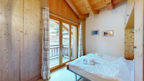 a bedroom with a bed and a large window at Plein Ciel VA 050 - MOUNTAIN apartment 6 pers in Veysonnaz