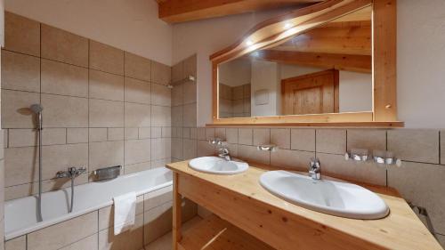 a bathroom with two sinks and a mirror at Plein Ciel VA 050 - MOUNTAIN apartment 6 pers in Veysonnaz