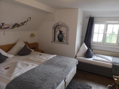 a bedroom with two beds and a window at Hotel DreiKönig & Restaurant SeeGourmet in Hagnau