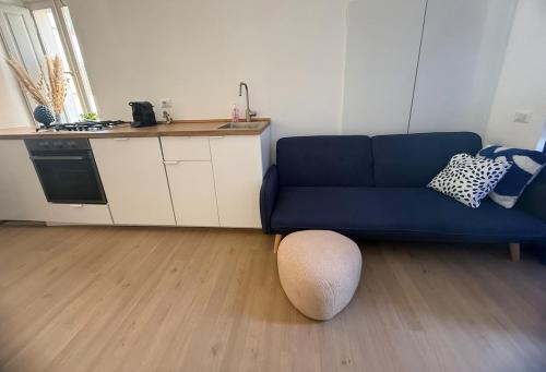 a living room with a blue couch and a ottoman at Cairoli House- Grottammare in Grottammare