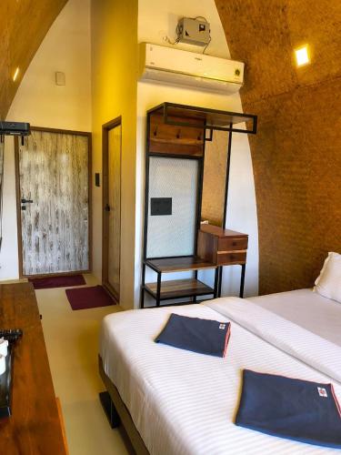 a bedroom with two beds and a desk and a piano at Gambhiraa Resorts in Kolli Hills