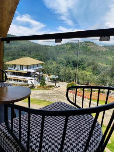 a balcony with a table and a view of a mountain at Gambhiraa Resorts in Kolli Hills