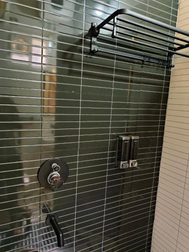 a shower with a black tiled wall at Gambhiraa Resorts in Kolli Hills