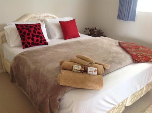 a bed with two towels and pillows on it at Luxury Room in large House in Auckland