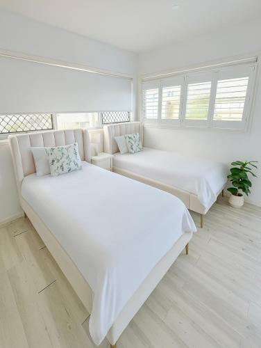 a white room with two beds and a couch at Self contained guest house Gold Coast - sleeps max 4 in Gold Coast