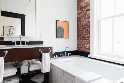 a bathroom with a large tub and a sink at The Dwell Hotel, a Member of Design Hotels in Chattanooga
