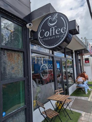 a coffee shop with a sign on the front of it at Casa Encantosyour ideal beachfront destination in Las Coles