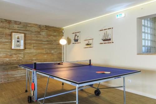 a ping pong table in the middle of a room at Sea-view villa in Quelfes + Shared pool in Quelfes