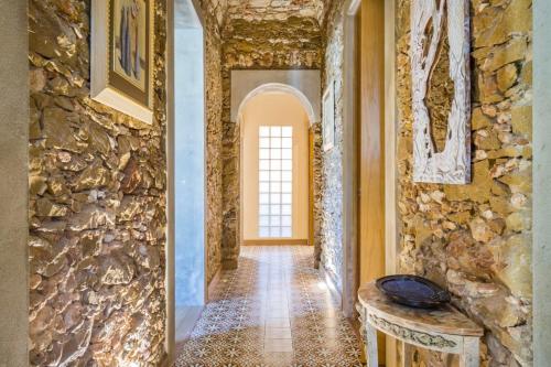 a hallway of a house with a stone wall at Spacious house with sea view in Quelfes, shared pool in Quelfes