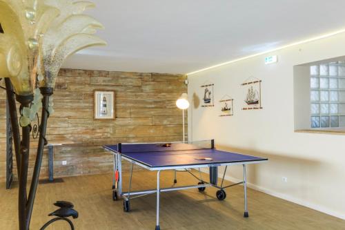 a ping pong table in the middle of a room at Spacious house with sea view in Quelfes, shared pool in Quelfes