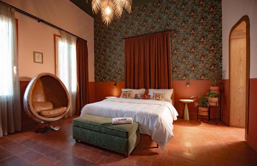 a bedroom with a large bed and a chair at Villa Saf in Bharsaf