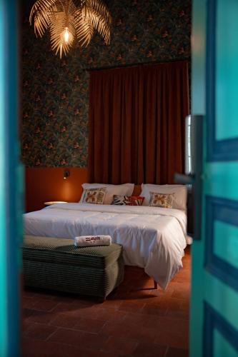 a bedroom with a bed with white sheets and a chandelier at Villa Saf in Bharsaf