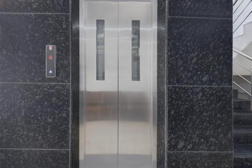 a glass elevator door in a building at Collection O Mahadevapura Opposite Phoenix Mall in Bengaluru