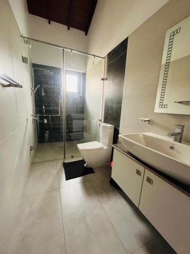 un baño con inodoro y lavabo en Sunrise Negombo Villa Bens, en Negombo