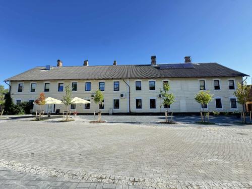 a large white building with trees in front of it at Guesthouse Carl Schmidt in Põltsamaa