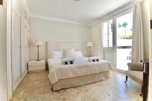 a white bedroom with a large bed and a window at Casa Maspalomas private pool, Bbq and private parking in Maspalomas