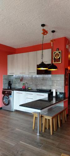 Una cocina con paredes rojas y una mesa con bancos. en Apartment Lux Pearl of Ureki, en Ureki